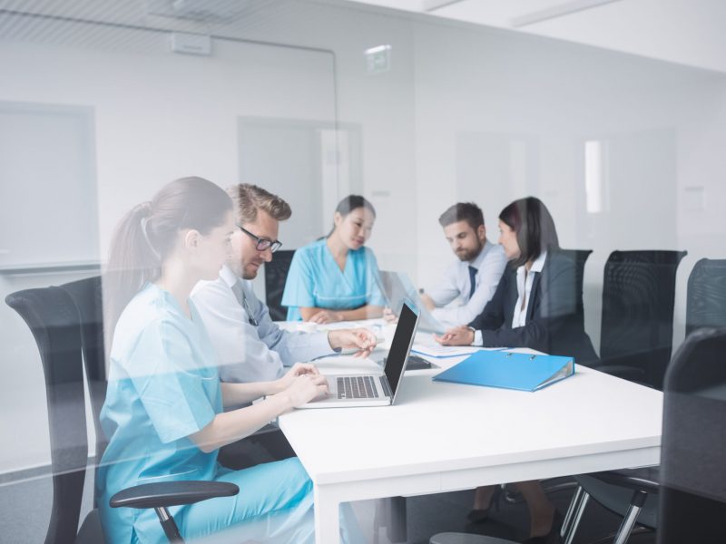 Doctors discussing over laptop in meeting at conference room